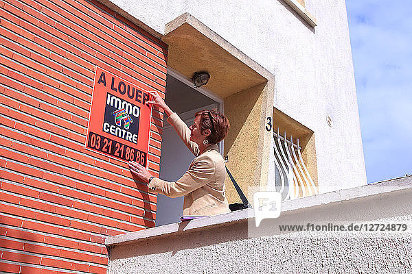 Frankreich  Immobilienmakler  der eine Anzeige für eine Wohnung schaltet.