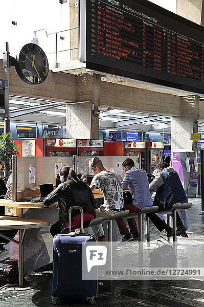 France  Nantes City  travelers seated in the multimedia space in departure hall of railway station  internet access  electrical outlets.