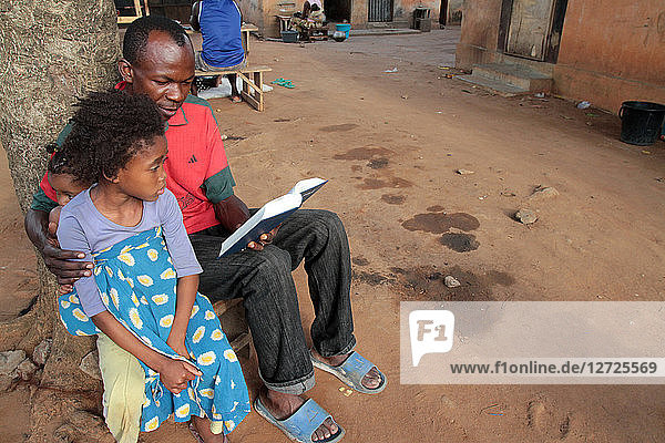 A father and daughter reading the Bible. Lome. Togo.