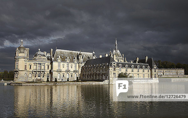 Frankreich  Schloss Chantilly  Gesamtansicht mit den Bassins an einem stürmischen Abend