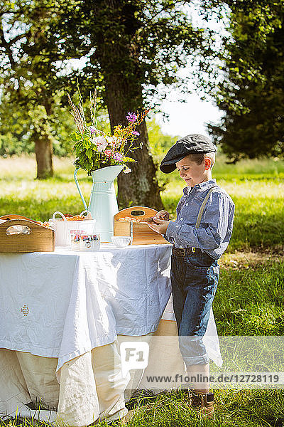 Ein Junge toastet eine Scheibe Brot bei einem Brunch auf dem Land. Obligatorischer Kredit: Design culinaire : food-design-studio.fr