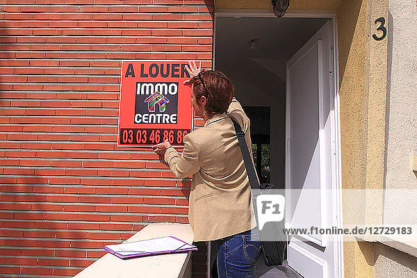 Frankreich  Immobilienmakler  der eine Anzeige für eine Wohnung schaltet.