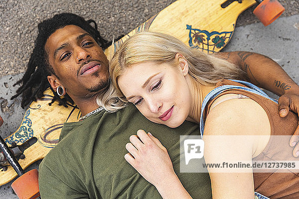 Portrait of multicultural young couple with longboard relaxing together