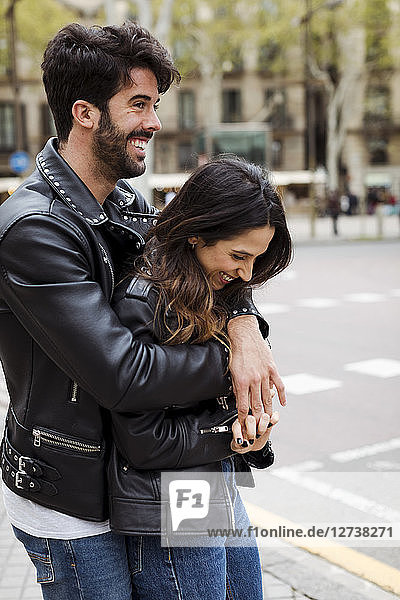 Spain  Barcelona  happy young couple hugging on the street
