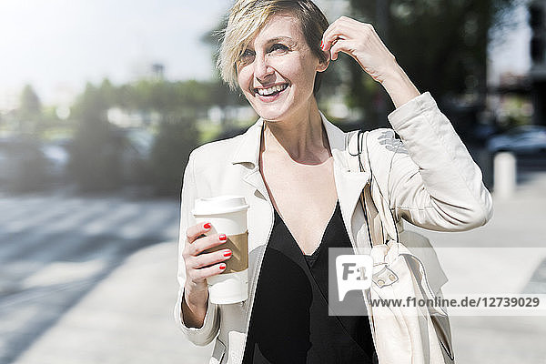 Portrait of laughing businesswoman with Coffee to go
