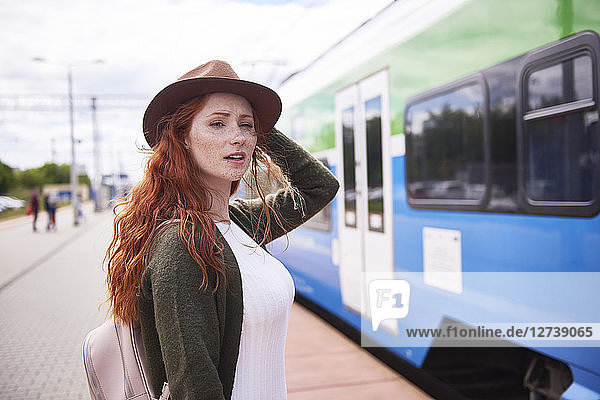 Portrait of redheaded woman waiting at platform
