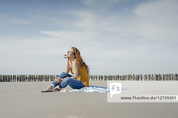 Woman sitting on the beach  enjoying the sun