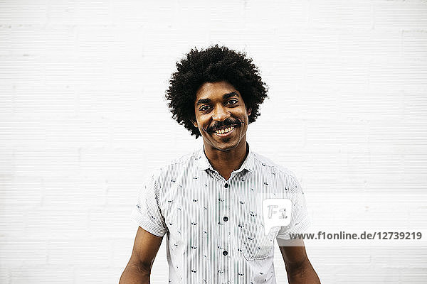 Portrait of laughing man in front of white wall