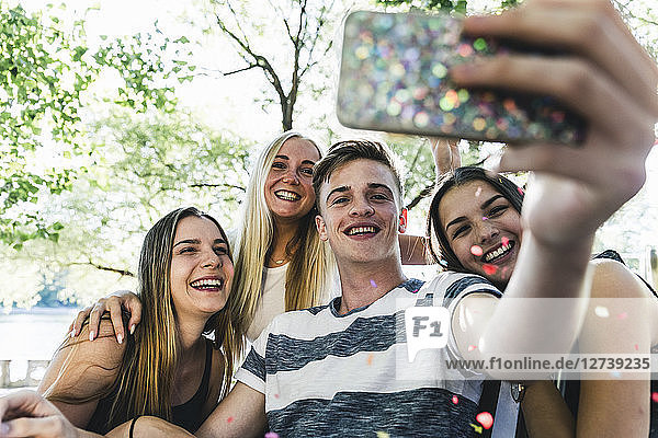 Group of happy friends taking a selfie outdoors