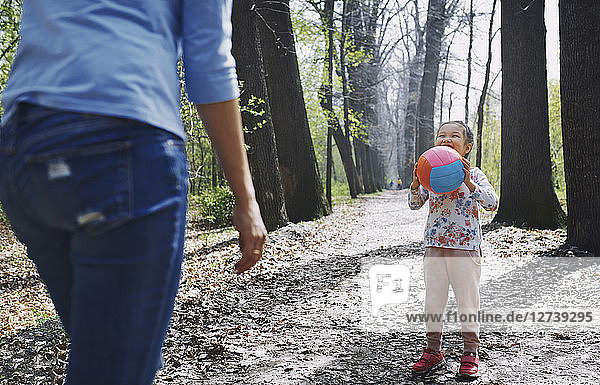 Mother and daughter playing ball in a park