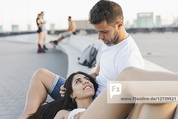 Happy young woman lying on lap of her boyfriend  portrait