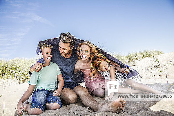 Netherlands  Zandvoort  happy family under a blanket on the beach