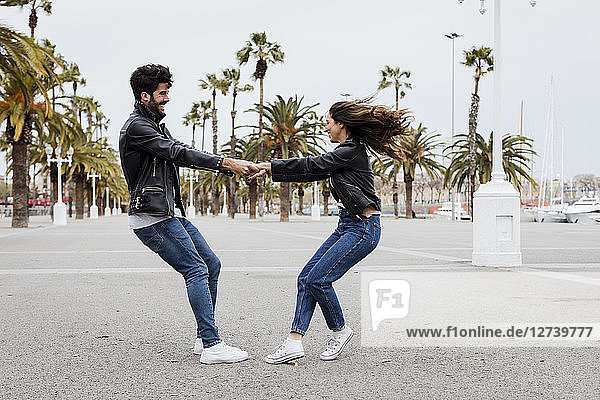 Spain  Barcelona  happy young couple having fun on promenade with palms