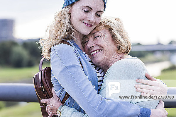 Happy grandmother and granddaughter hugging each other