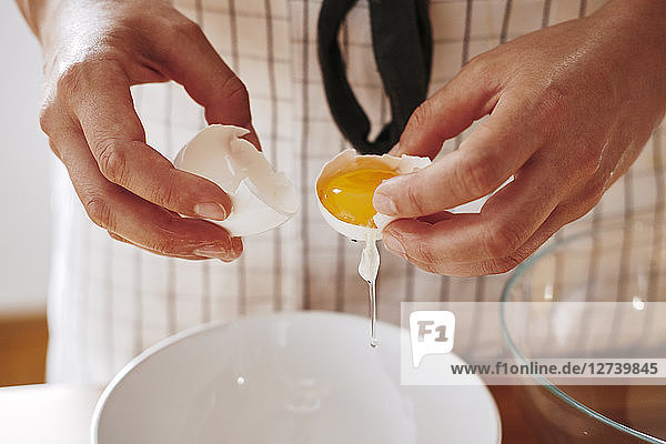Woman's hands separating egg  close-up