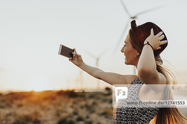Young woman taking selfie at sunset
