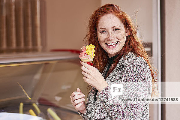 Portrait of happy redheaded woman with ice cream cone