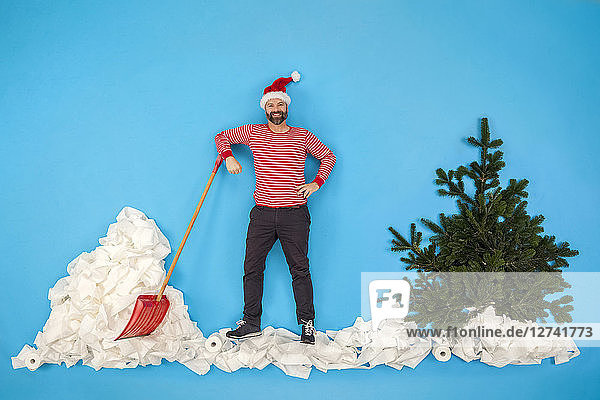 Man with Santa hat shoveling snow
