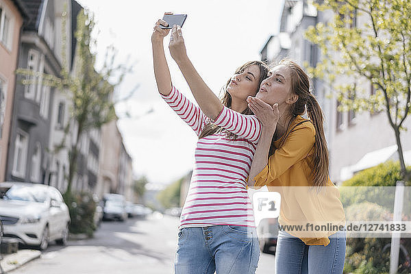 Girlfriends taking selfie in the city