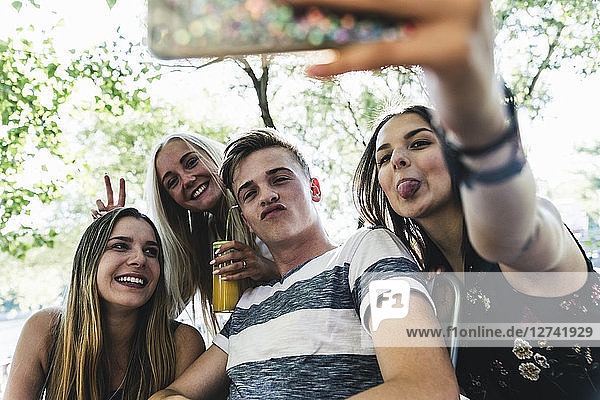 Group of happy friends taking a selfie outdoors