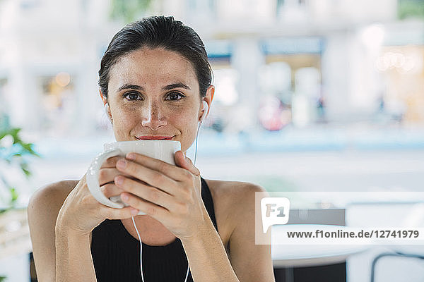 Young businesswoman sitting in coffee shop  taking a break  drinking tea