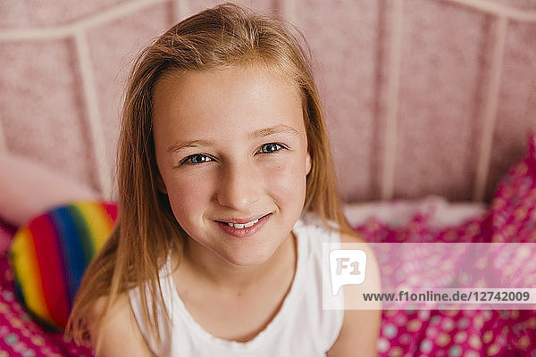 Portrait of smiling little girl in bedroom