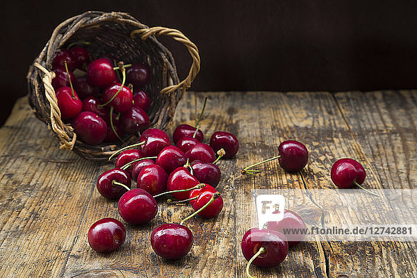 Wickerbasket of cherries on wood