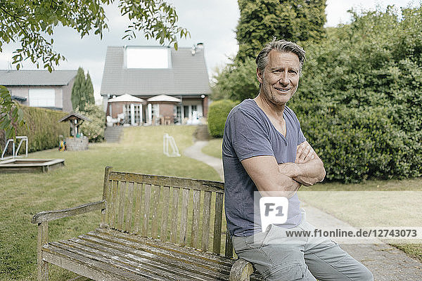 Portrait of smiling mature man in garden of his home