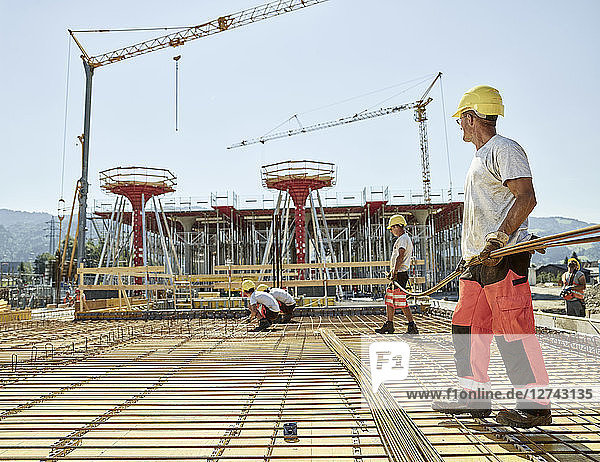 Workers on construction site preparing iron rods