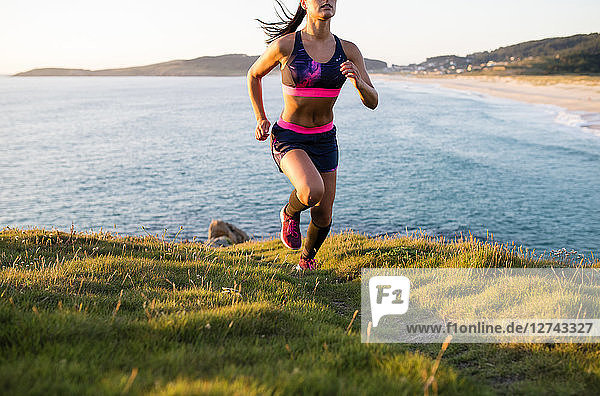 Woman running in a coastal landscape