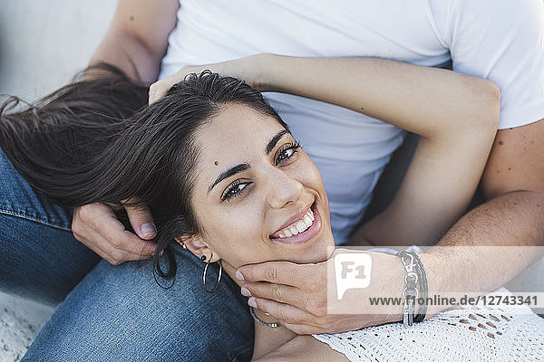 Happy young woman lying on lap of her boyfriend  portrait