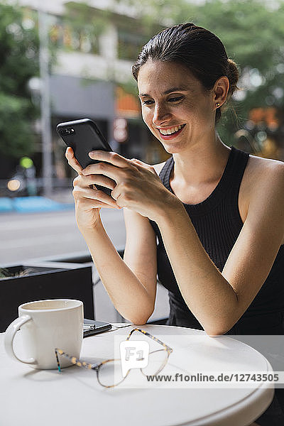 Young woman sitting in cofee shop  using smartphone