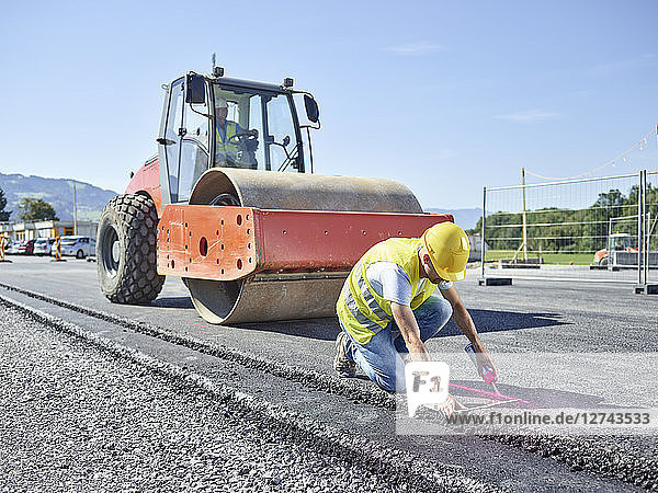 Worker marking roadside on construction site