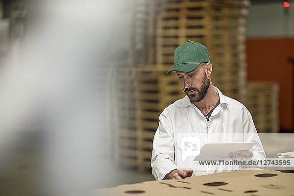Worker using tablet in factory