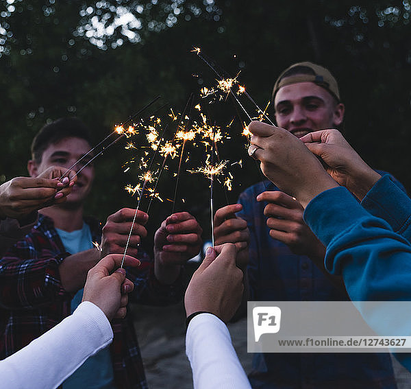 Group of friends holding sparklers in the evening