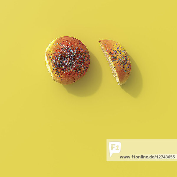 3D rendering  Halved poppy seed roll on yellow background