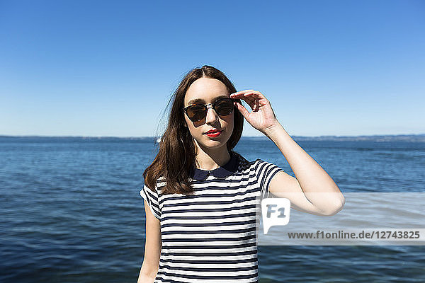 Italy  Lake Garda  portrait of young woman wearing sunglasses