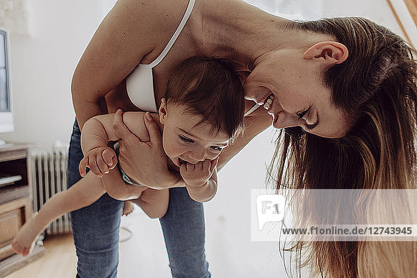Mother playing with her baby son at home