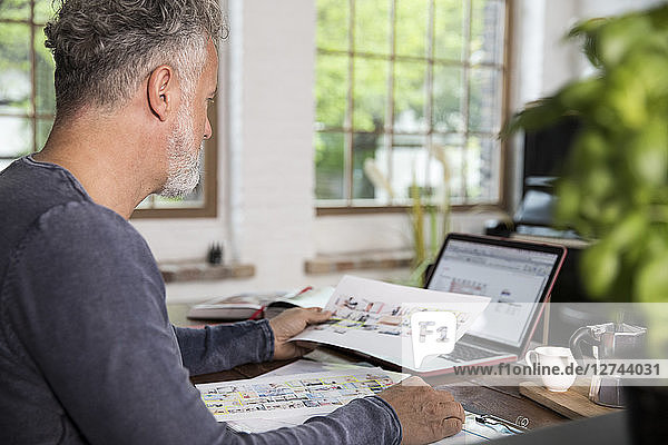 Mature man working in his home office at a loft apartment