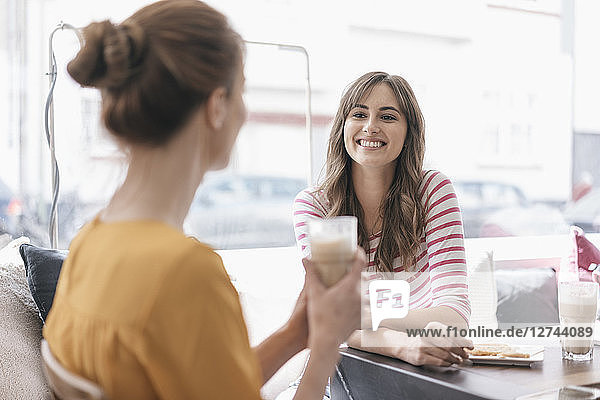 Two girlfriends meeting in a coffee shop  talking