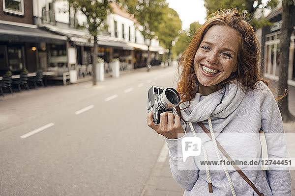 Redheaded woman using analogue camera