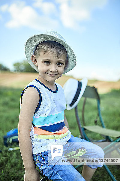Portrait of smiling little boy wearing summer hat