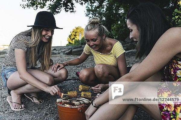 Three young women sitting together having a barbecue