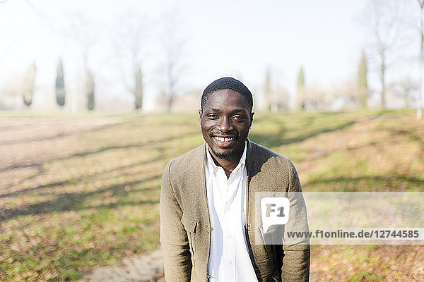 Portrait ogf young man in park  wearing jacket  smiling