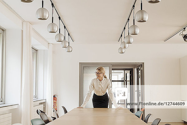 Smiling businesswoman standing in conference room