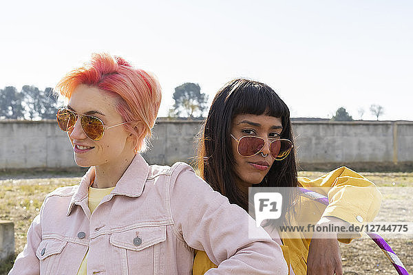 Two alternative friends wearing yellow and pink jeans jackets