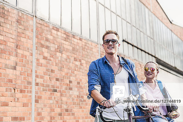 Young couple with bicycle and sunglasses on the move