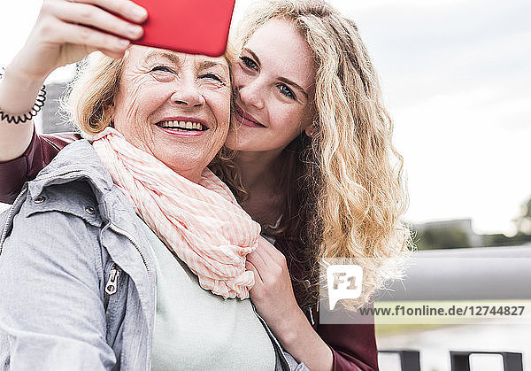 Grandmother and granddaughter taking selfie with smartphone