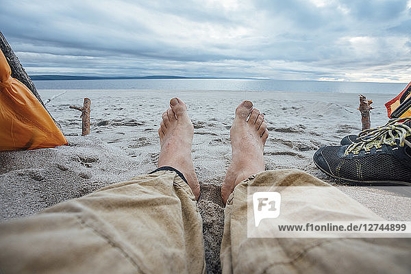 Feet of man  lying on the beach