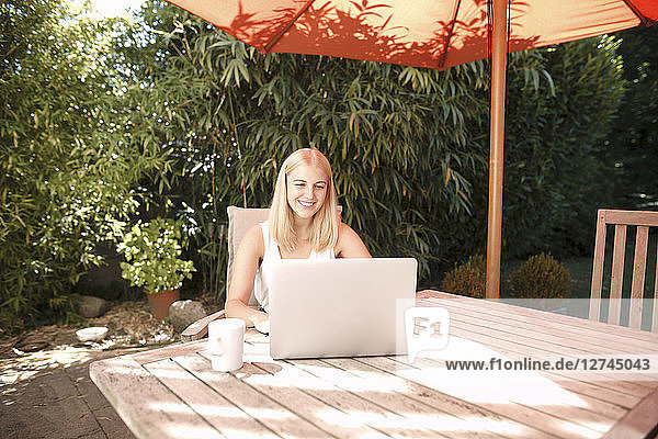 Young woman using laptop in garden